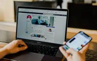 person using both laptop and smartphone